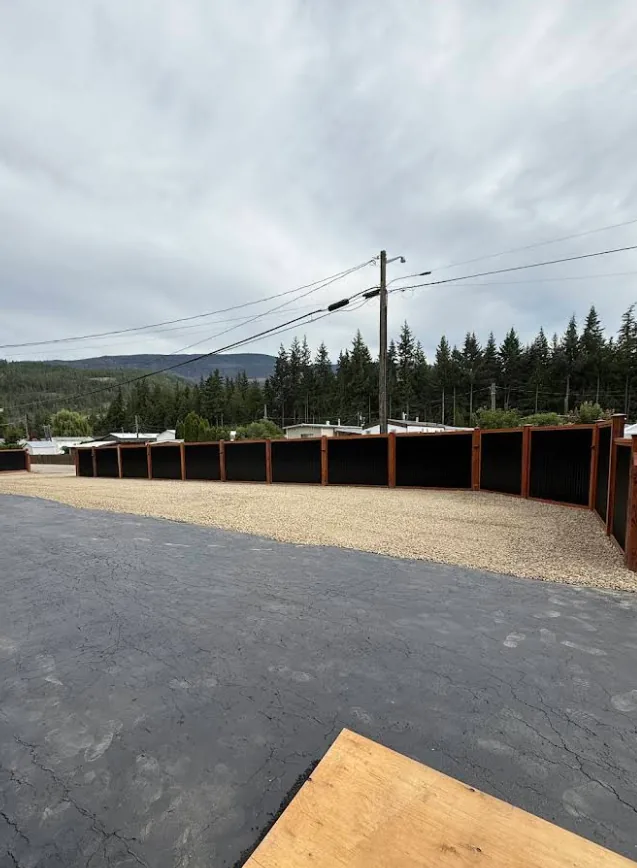 Curved black metal fence line with stained-wood frame wrapping a large lot