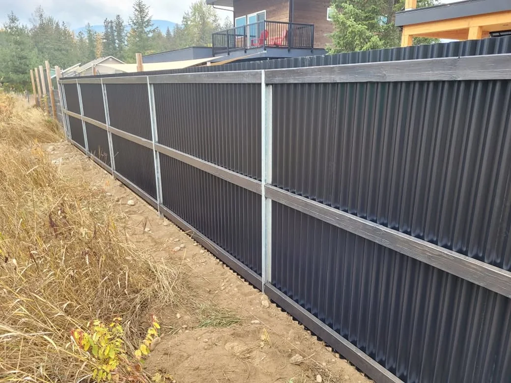 Black corrugated metal privacy fence with steel posts