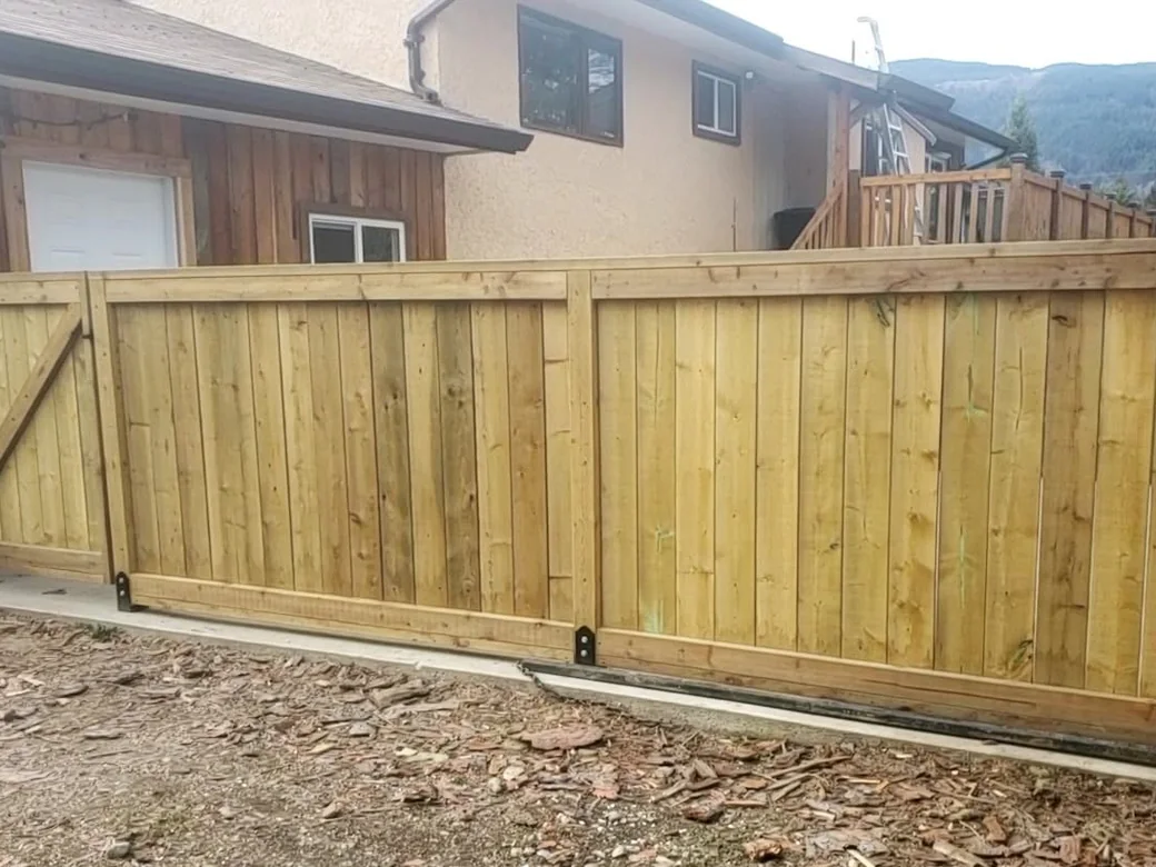 Cedar wood privacy fence and gate beside a home