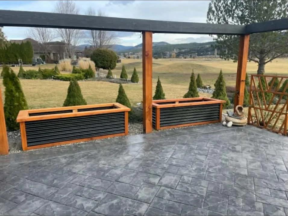 Matching pair of wood and metal planter boxes along a covered patio